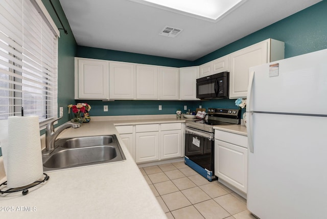 kitchen with white cabinetry, sink, white fridge, light tile patterned floors, and stainless steel electric range