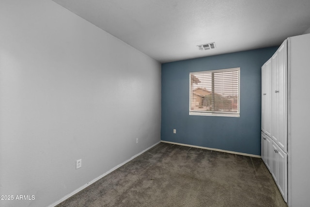 unfurnished bedroom with dark colored carpet