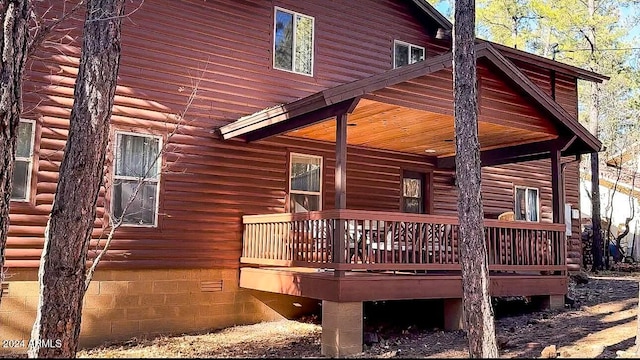 view of property exterior with a wooden deck