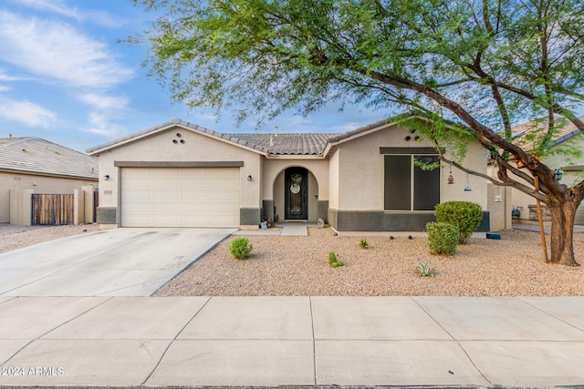 single story home featuring a garage, driveway, a tiled roof, and stucco siding