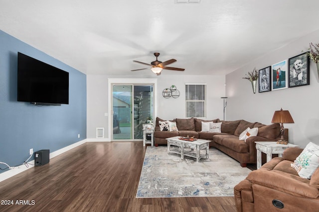 living room with visible vents, ceiling fan, baseboards, and wood finished floors