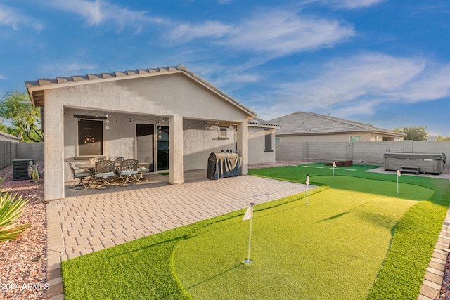 back of property with a patio area, a hot tub, a fenced backyard, and stucco siding