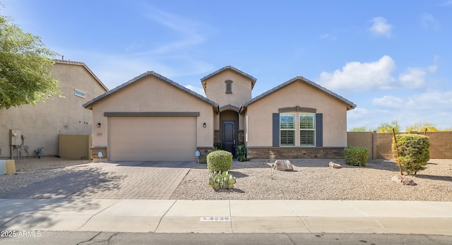 4229 W Magdalena Ln, Laveen, AZ 85339 - ranch-style home featuring fence, an attached garage, stone siding, stucco siding, and decorative driveway