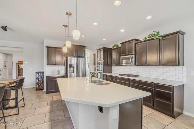 4229 W Magdalena Ln, Laveen, AZ 85339 - kitchen with appliances with stainless steel finishes, tasteful backsplash, dark brown cabinets, a sink, and light countertops