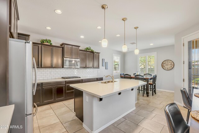 4229 W Magdalena Ln, Laveen, AZ 85339 - kitchen with dark brown cabinets, recessed lighting, tasteful backsplash, a sink, and stainless steel appliances