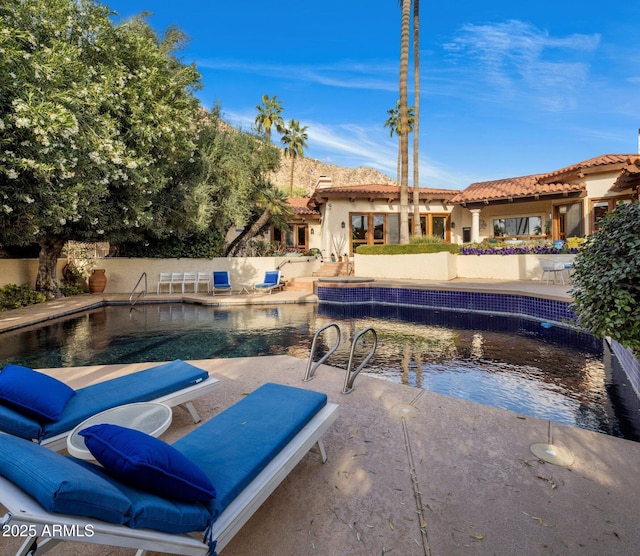 outdoor pool with a patio and fence