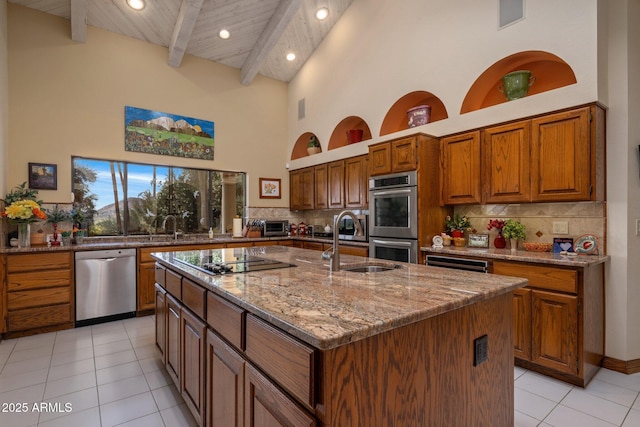 kitchen featuring a sink, beamed ceiling, tasteful backsplash, and appliances with stainless steel finishes