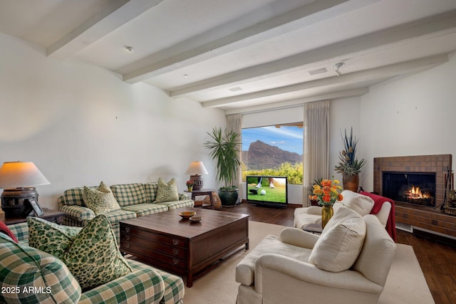 living area with wood finished floors, a fireplace, and beam ceiling