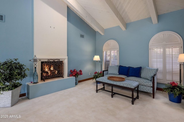 living room featuring visible vents, carpet floors, high vaulted ceiling, a lit fireplace, and beamed ceiling