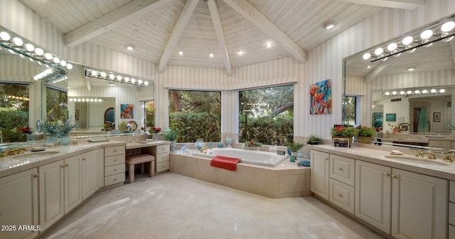 bathroom featuring two vanities, lofted ceiling with beams, a bath, and a sink