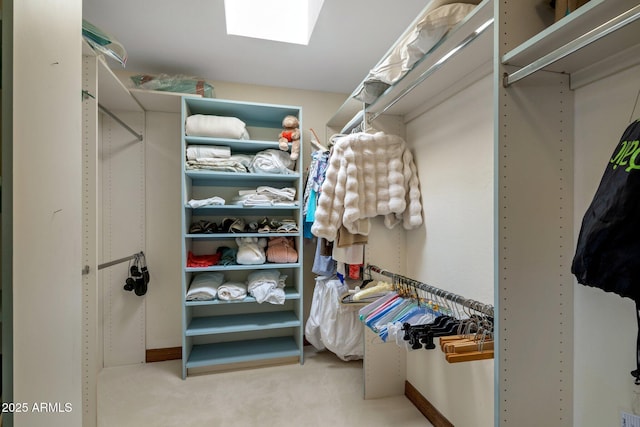 spacious closet with a skylight and carpet flooring