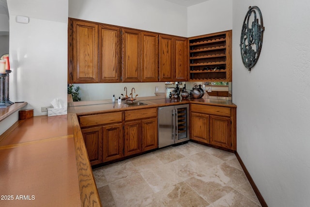 kitchen with baseboards, open shelves, a sink, wine cooler, and brown cabinets