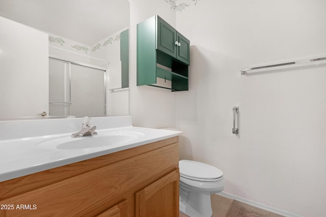 full bathroom with toilet, a stall shower, baseboards, and vanity