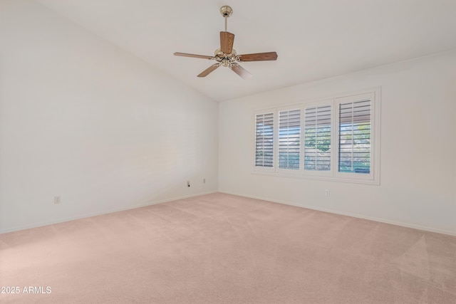 spare room featuring light carpet, ceiling fan, baseboards, and vaulted ceiling