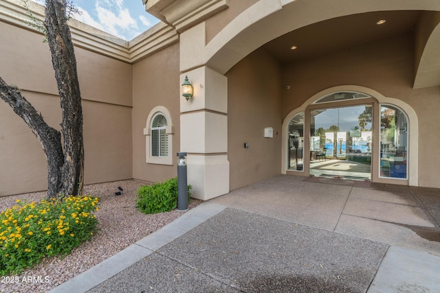 property entrance featuring a patio area and stucco siding
