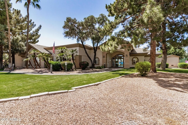 mediterranean / spanish home featuring stucco siding, a tiled roof, french doors, and a front lawn