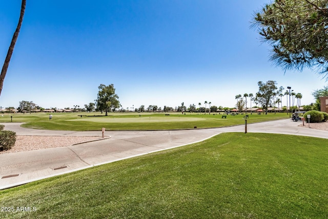 view of community with golf course view and a lawn