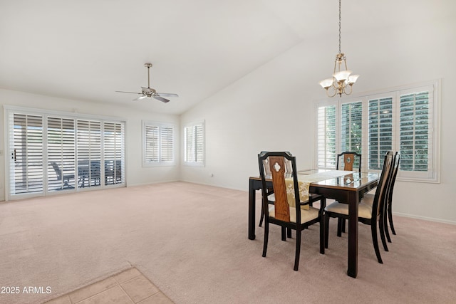 dining space featuring ceiling fan with notable chandelier, high vaulted ceiling, baseboards, and carpet