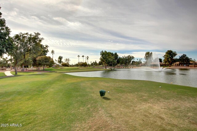 surrounding community featuring a water view, a yard, and view of golf course