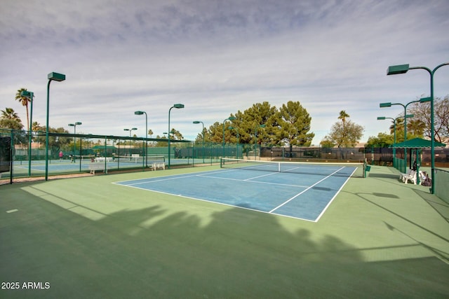 view of tennis court featuring fence