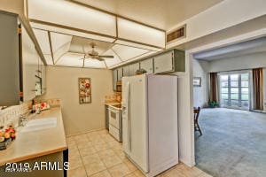 kitchen with white appliances, light colored carpet, ceiling fan, and sink