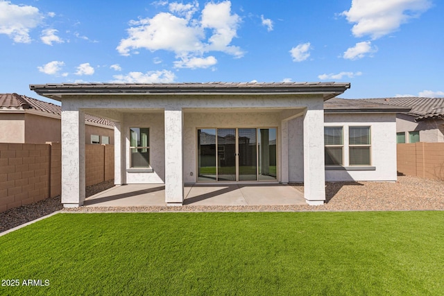 rear view of property with a patio, a yard, a fenced backyard, and stucco siding