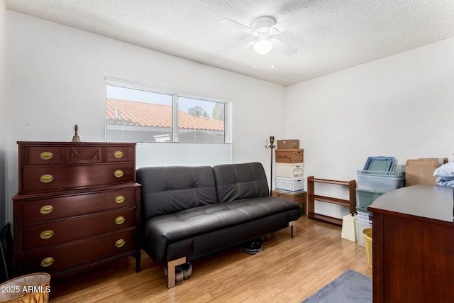 interior space featuring ceiling fan, a textured ceiling, and light wood-type flooring