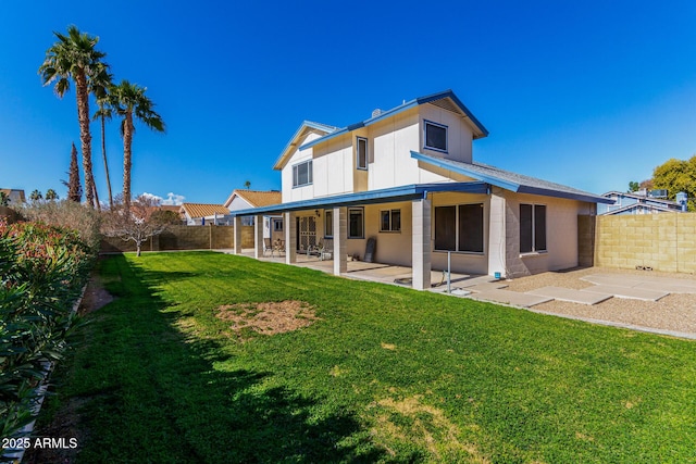 back of property featuring a patio and a yard