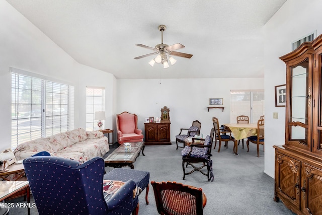 carpeted living room with ceiling fan and lofted ceiling