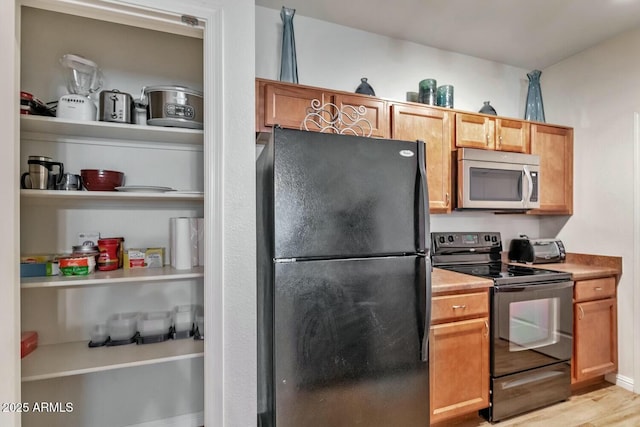 kitchen with light wood-type flooring and black appliances