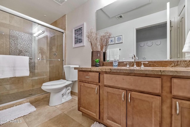 bathroom featuring a stall shower, vanity, toilet, and tile patterned floors