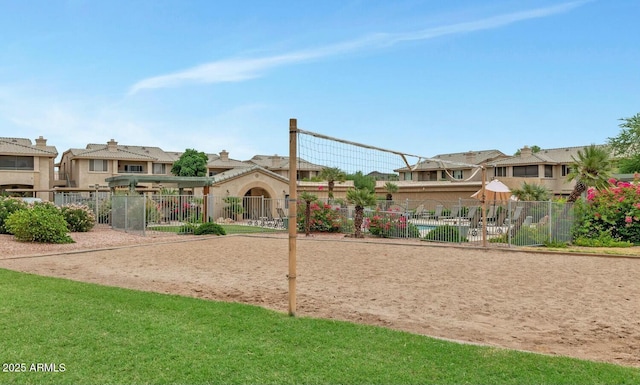 view of community with volleyball court, fence, and a residential view