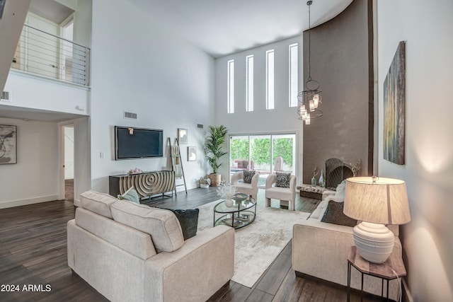 living room featuring a towering ceiling and dark hardwood / wood-style flooring