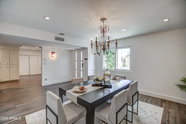 dining area with a notable chandelier and dark hardwood / wood-style floors