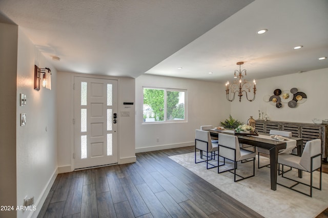 dining space featuring a textured ceiling, hardwood / wood-style floors, and a notable chandelier