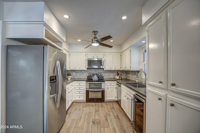 kitchen featuring wine cooler, stainless steel appliances, sink, ceiling fan, and light hardwood / wood-style floors