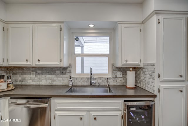 kitchen with dishwasher, beverage cooler, sink, and white cabinets