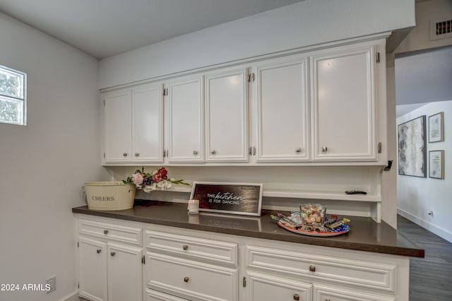 kitchen with dark wood-type flooring and white cabinets