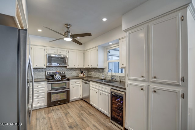 kitchen featuring white cabinets, stainless steel appliances, light hardwood / wood-style floors, sink, and beverage cooler