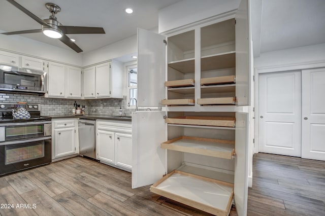 kitchen featuring stainless steel appliances, white cabinetry, sink, wood-type flooring, and ceiling fan