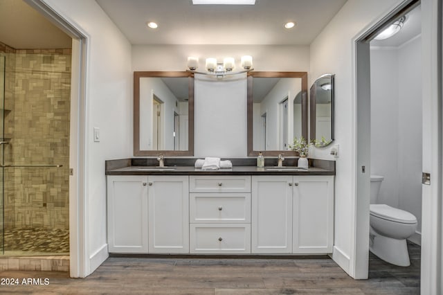 bathroom with a shower with door, vanity, toilet, and hardwood / wood-style floors