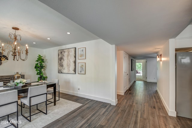 dining area with dark wood-type flooring and a chandelier