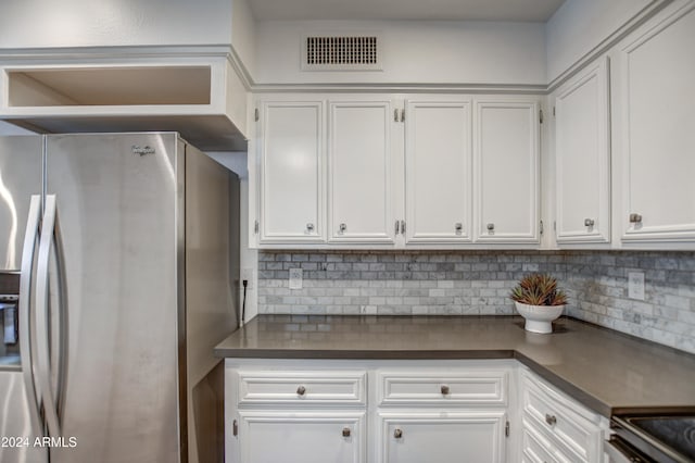 kitchen featuring stainless steel appliances, backsplash, and white cabinets