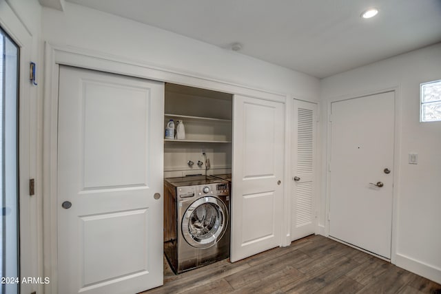 clothes washing area with washer / dryer and dark hardwood / wood-style floors