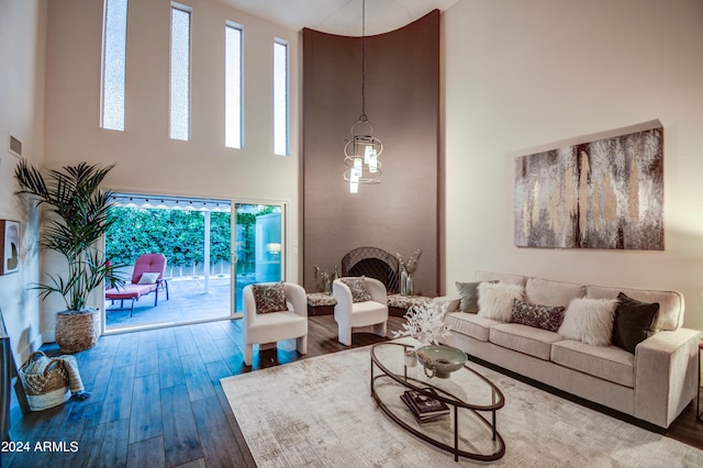 living room with hardwood / wood-style flooring, plenty of natural light, and a high ceiling