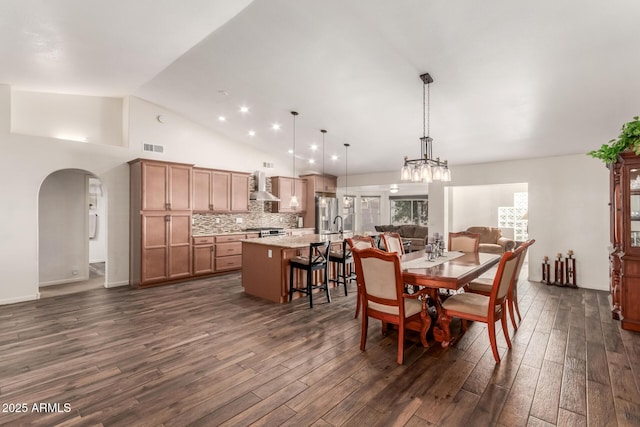 dining space with dark wood-type flooring and high vaulted ceiling