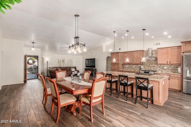 dining room featuring lofted ceiling, sink, and hardwood / wood-style floors