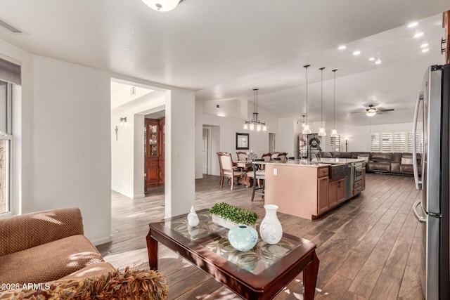 living room featuring lofted ceiling, sink, dark hardwood / wood-style floors, and ceiling fan