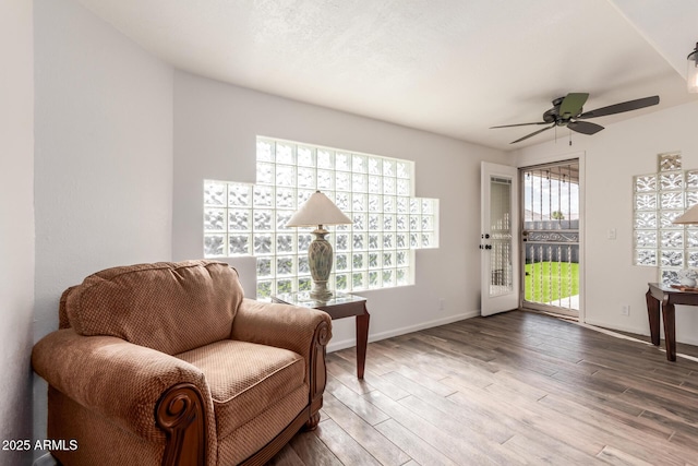 living area featuring hardwood / wood-style floors and ceiling fan