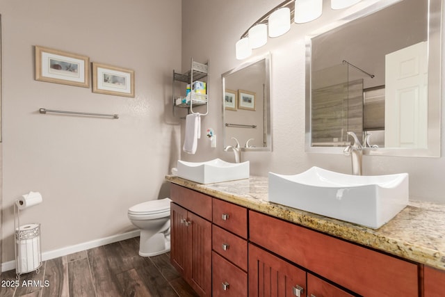 bathroom featuring hardwood / wood-style flooring, vanity, toilet, and a shower with door